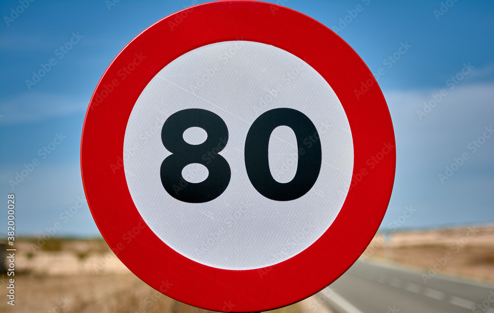 detail of a round traffic sign with red border and black limit number