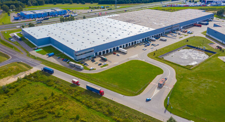 Sticker - Aerial view of goods warehouse. Logistics center in industrial city zone from above. Aerial view of trucks loading at logistic center. View from drone.
