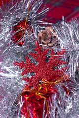 new years decorations - red presents, cones and snowflakes in silver tinsel for christmas tree.