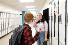 Girl With Phone Photographing Boy In School Corridor