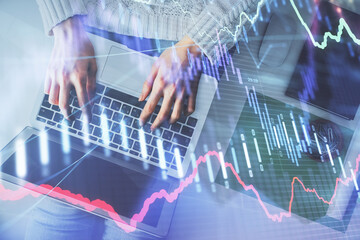 Multi exposure of woman hands working on computer and forex chart hologram drawing. Top View. Financial analysis concept.