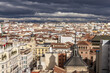 Red rooftops and various vintage buildings in urban Madrid Spain with cloudy sky