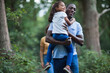 © Paul Bradbury/Caia Image - Happy father carrying daughter on hike in woods