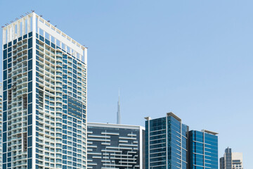 Tops of glass and steel skyscrapers of financial downtown of Dubai, UAE at sunny day. Building exteriors of the capital of the Emirate of Dubai. A trading international hub of Western Asia.