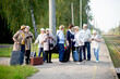 © Zelma - A group of positive senior elderly people travelers using tablets waiting for train before going on a trip..
