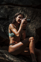 Sticker - Attractive young female taking pictures at a waterfall in the forest