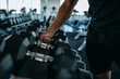 © bnenin - Man in black doing exercise with weight.