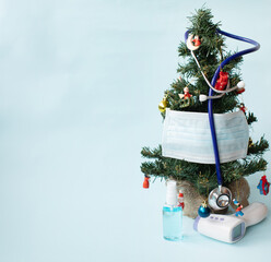christmas tree decorated with stethoscope and blue face masks. covid and happy new year concept. cor
