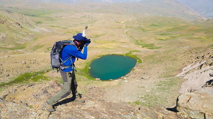 person with backpack walking in mountains