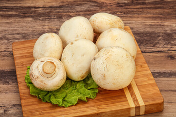 Raw champignons over the board