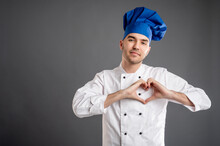 Young Male Dressed In A White Chef Suit Showing Heart Sign With Hands