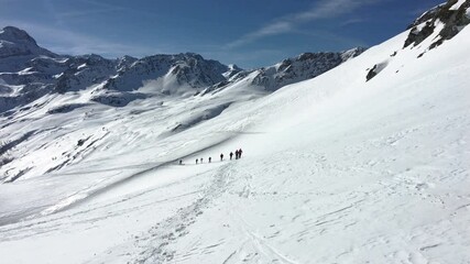 Wall Mural - hikers, ski tourers go up a snow slope in the mountains in winter.