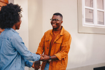 Wall Mural - Young handsome african american hipster couple holding hands and being happy while standing on the street.