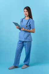 Young woman in nurse uniform standing and smile isolated on light blue background.