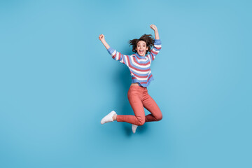 Full length body size photo of jumping high funky careless young girl keeping hands up isolated on vibrant blue color background