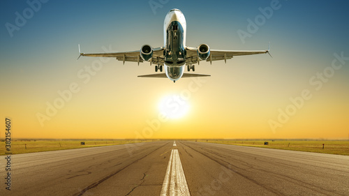 Tela commercial airplane takes off against a sunset