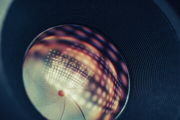 Poster - Beautiful Camera Lens on a dark with yellow shine reflection light background. Macro view.