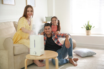 Canvas Print - Family near modern air humidifier at home