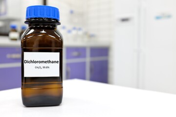 Sticker - Selective focus of dichloromethane liquid chemical compound in dark glass bottle inside a chemistry laboratory with copy space.