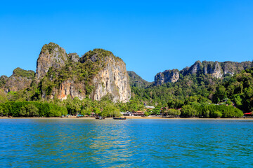 Wall Mural - Turquoise crystal clear sea water with limestone cliff and mountain at Railay East Beach, Krabi, Thailand