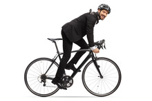 Profile Shot Of A Man In A Suit Riding A Bicycle To Work