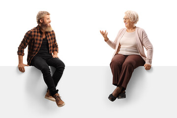 Young bearded man sitting on a white panel board and listening to an older woman