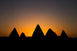 Silhouettes of pyramids in Sudan with sunrise background