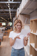 © mad_production - Vertical portrait of a female customer shopping for new furniture for her apartment