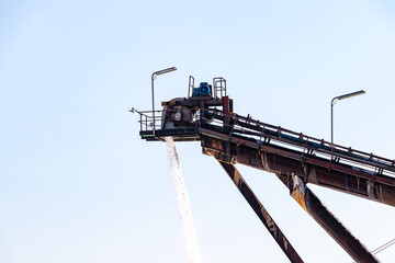 Salt production, conveyor belt with marine salt produced by the evaporation of seawater.