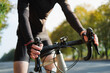 Hands of a cyclist resting on road bike handlebars. Cycling, bicycle sport training outdoors