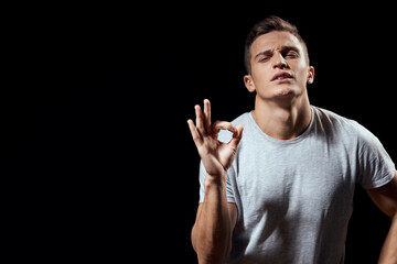 handsome man in white t-shirt on black background inflated arm muscles sport model cropped view Copy Space