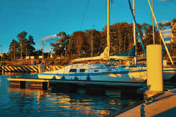 Poster - Sunset in the port. The concept of beautiful views over the sea. Moored boats and sailboats against the setting sun.