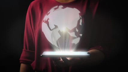 Woman against black background holds hologram projecting tablet in her hand. Bright digital rotating globe as a symbol for the worldwide network.