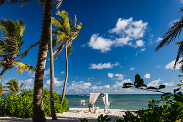 Poster - Wedding bamboo gazebo, decorated with tropical flowers and coloured fabrics on the paradise beach with palm trees, white sand and blue water of Caribbean Sea, Punta Cana, Dominican Republic