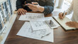 © PIC SNIPE - Engineer or architect teamwork working on construction project with building model and blueprint in office. Construction concept.