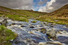 A Moorland River Rushes Downill Through A Valley, En Route From The Moors To The Sea, The River Tavy, In Dartmoor National Park, Devon, England, United Kingdom