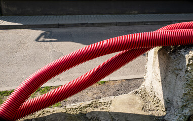 two plastic red pipes near the road on the construction