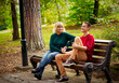 © khanfus - Beautiful woman,blonde,middle-aged,with her son,sitting on a bench and talking