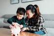 © MaaHoo Studio/Stocksy - Family saving money in a piggybank