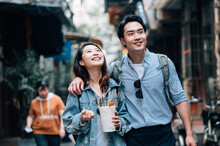 Young Asian Couple Traveling In A City Downtown And Enjoying Street Food