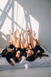 © Liliya Rodnikova/Stocksy - Four women posing with legs up in sunny studio