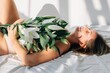 © Liliya Rodnikova/Stocksy - blond woman with bouquet of lilies