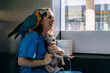 © Inuk Studio/Stocksy - Happy vet with parrot and dog