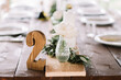 © Adrian Cotiga/Stocksy - Wooden number 2 on the wedding table