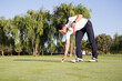 © Inuk Studio/Stocksy - Man putting golf ball on ground