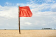 © Per Swantesson/Stocksy - Red warning flag on beach