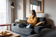 © Milles Studio/Stocksy - Woman using laptop on sofa at home