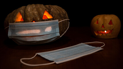 A closeup shot of a Halloween pumpkin with sanitary mask - concept of the new normal