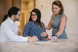 © Raymond Forbes LLC/Stocksy - Doula Meeting with Expectant Hispanic Couple at Home
