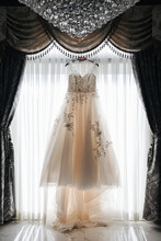Wedding Dress Hanging In Front Of A Window